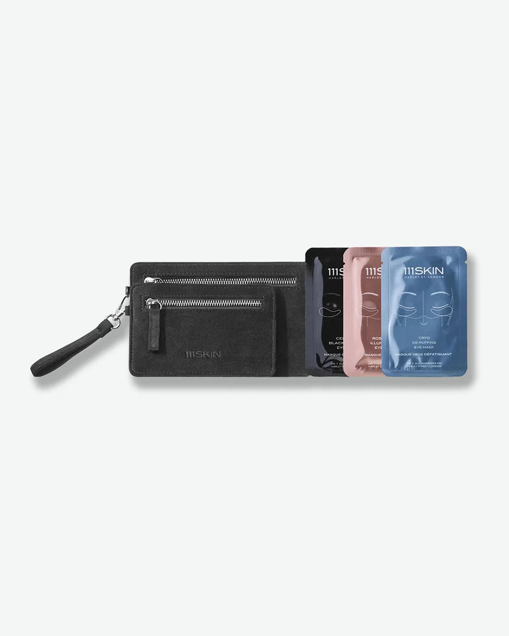 Black wallet with a strap on a white background, featuring 3 111skin face masks - one blue, pink, and black.