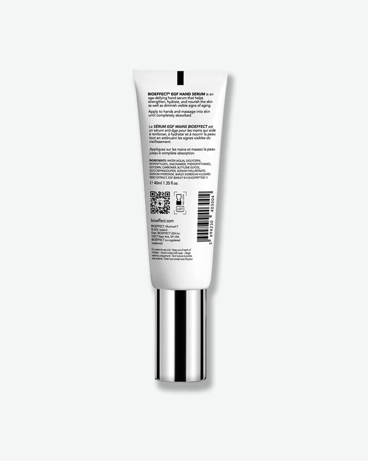 Backside view of white tube with silver cap standing cap-side down with ingredient, manufacturing, and usage information printed on.