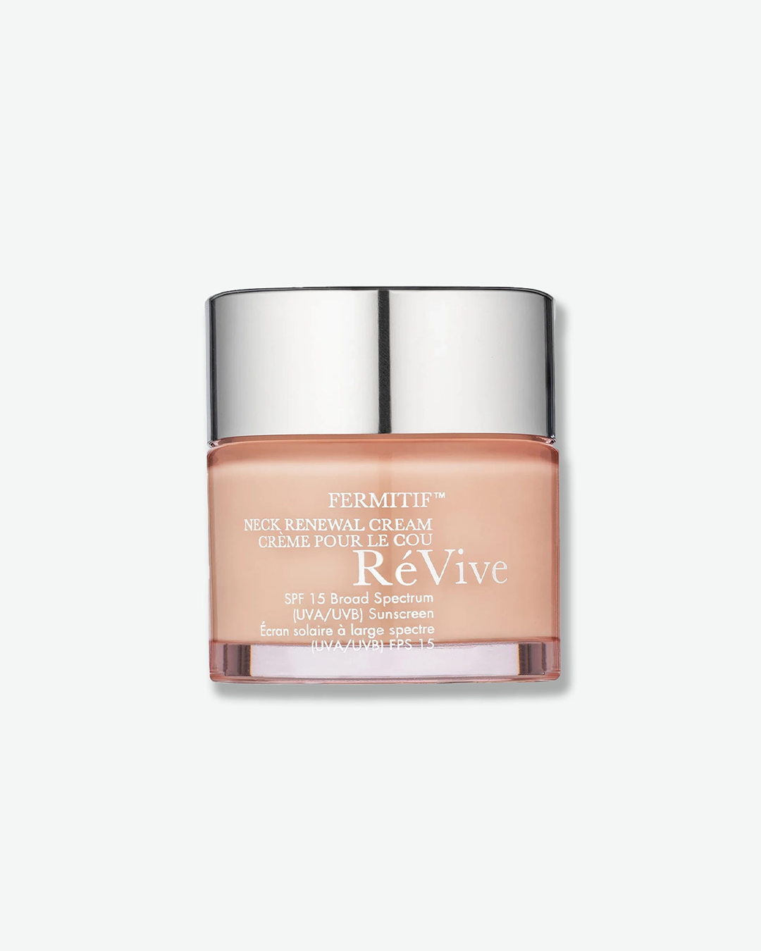 A product shot of a RéVive Fermitif Neck Renewal Cream jar, centered against a plain light gray background. The cylindrical glass jar features a soft peach color and is topped with a reflective chrome silver screw-on cap. The front displays white text detailing the product name, its French translation "CRÈME POUR LE COU", and its sun protection factor "SPF 15 Broad Spectrum (UVA/UVB) Sunscreen".