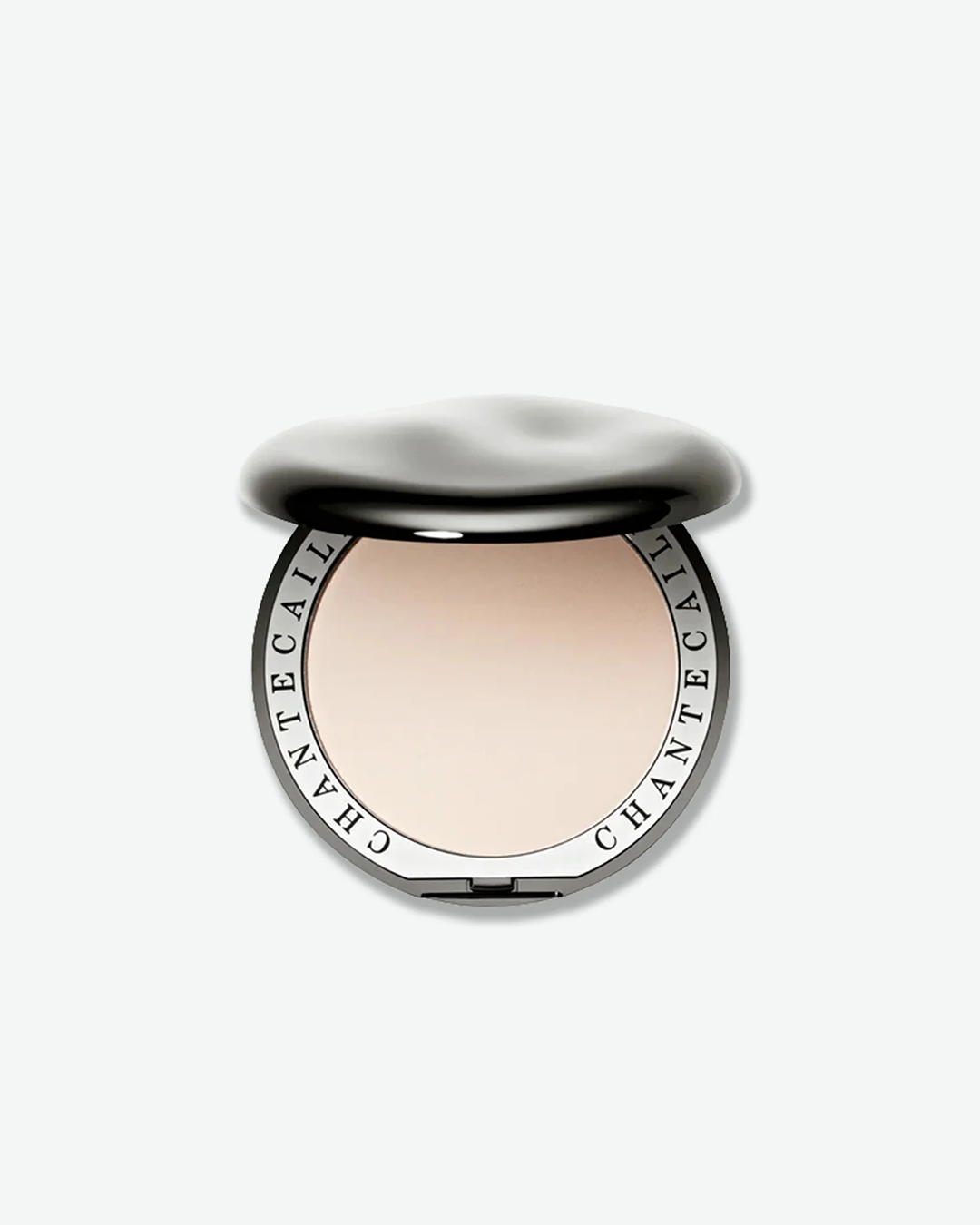 Chantecaille compact open to reveal a light, fair pressed powder face makeup, featuring the brand name engraved around the inner silver rim.