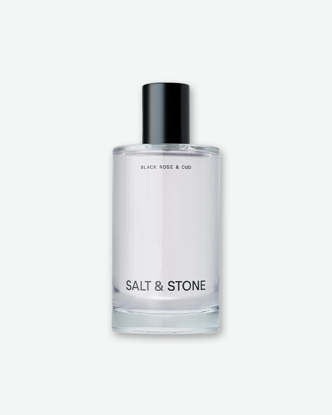 A studio product shot of Salt & Stone Black Rose & Oud Body Mist. The minimalist clear glass cylindrical bottle features a black atomiser cap, with 'BLACK ROSE & OUD' printed at the top and 'SALT & STONE' in bold black text at the bottom.