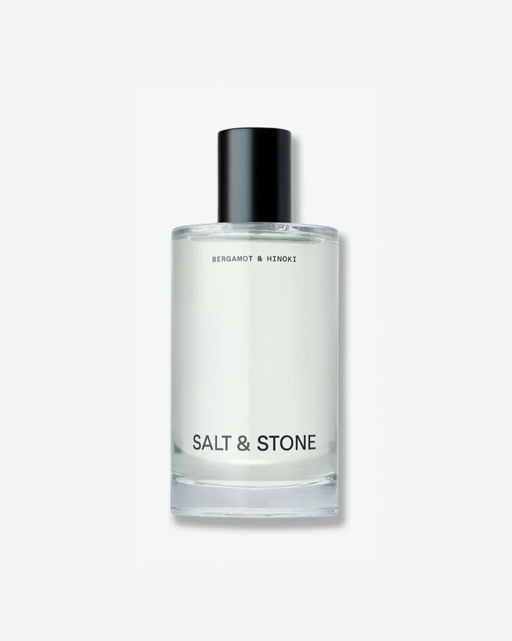 Salt & Stone Bergamot & Hinoki product in a minimalist clear glass bottle with a black cylindrical cap and bold black branding, isolated against a light grey background.