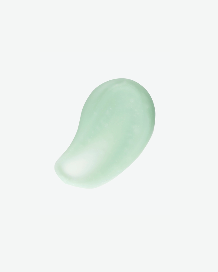 A top-down product texture shot featuring a smooth, teardrop-shaped dollop of translucent seafoam-green serum isolated against a solid white background.
