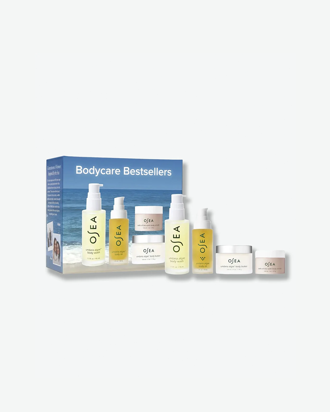 A product gift set shot featuring the OSEA "Bodycare Bestsellers" box. The blue rectangular packaging displays a serene ocean and horizon backdrop, with an array of six travel-sized skincare bottles and jars from the Undaria algae collection lined up neatly in front.