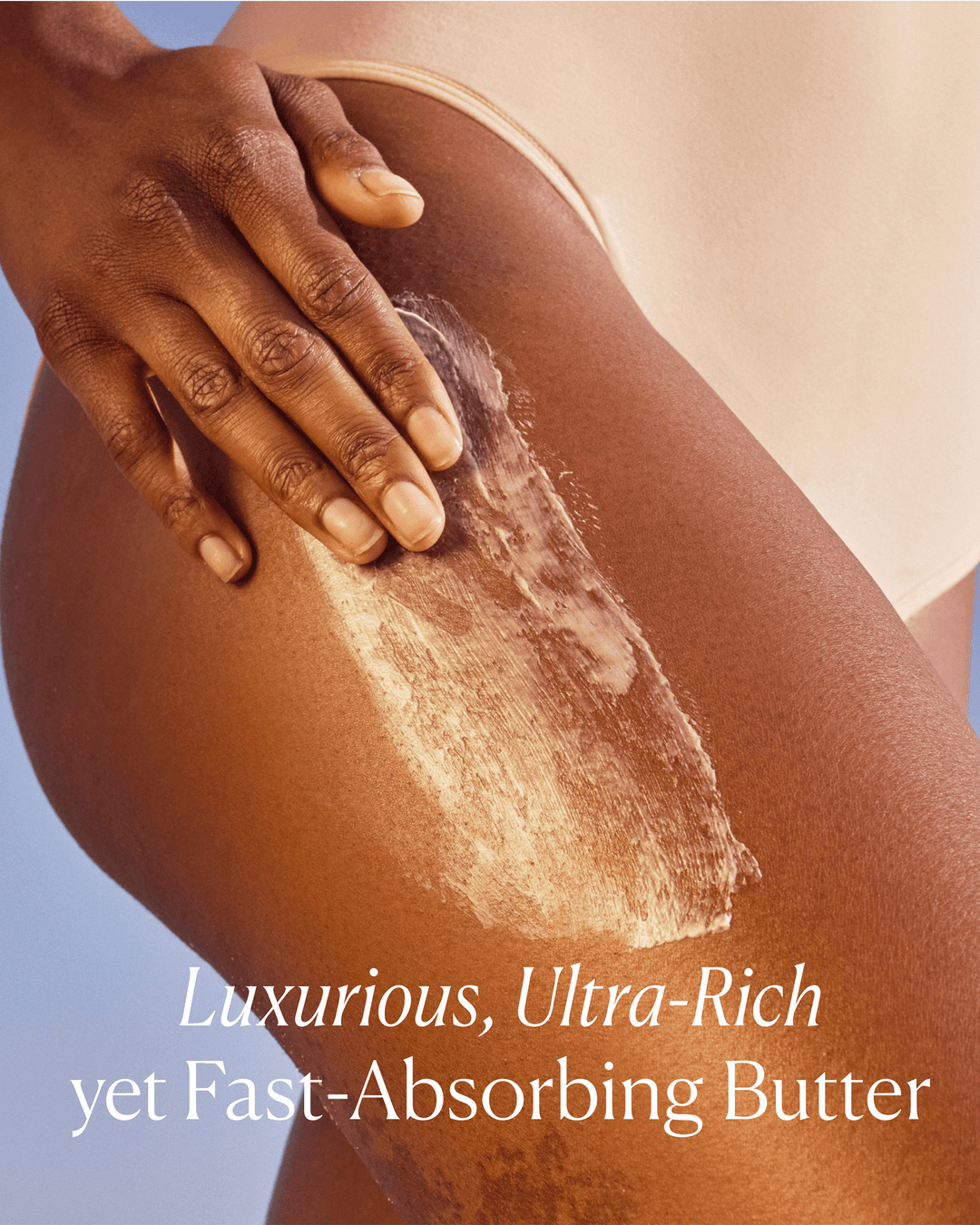 A hand smoothing a rich white cream onto a thigh, featuring the text "Luxurious, Ultra-Rich yet Fast-Absorbing Butter."