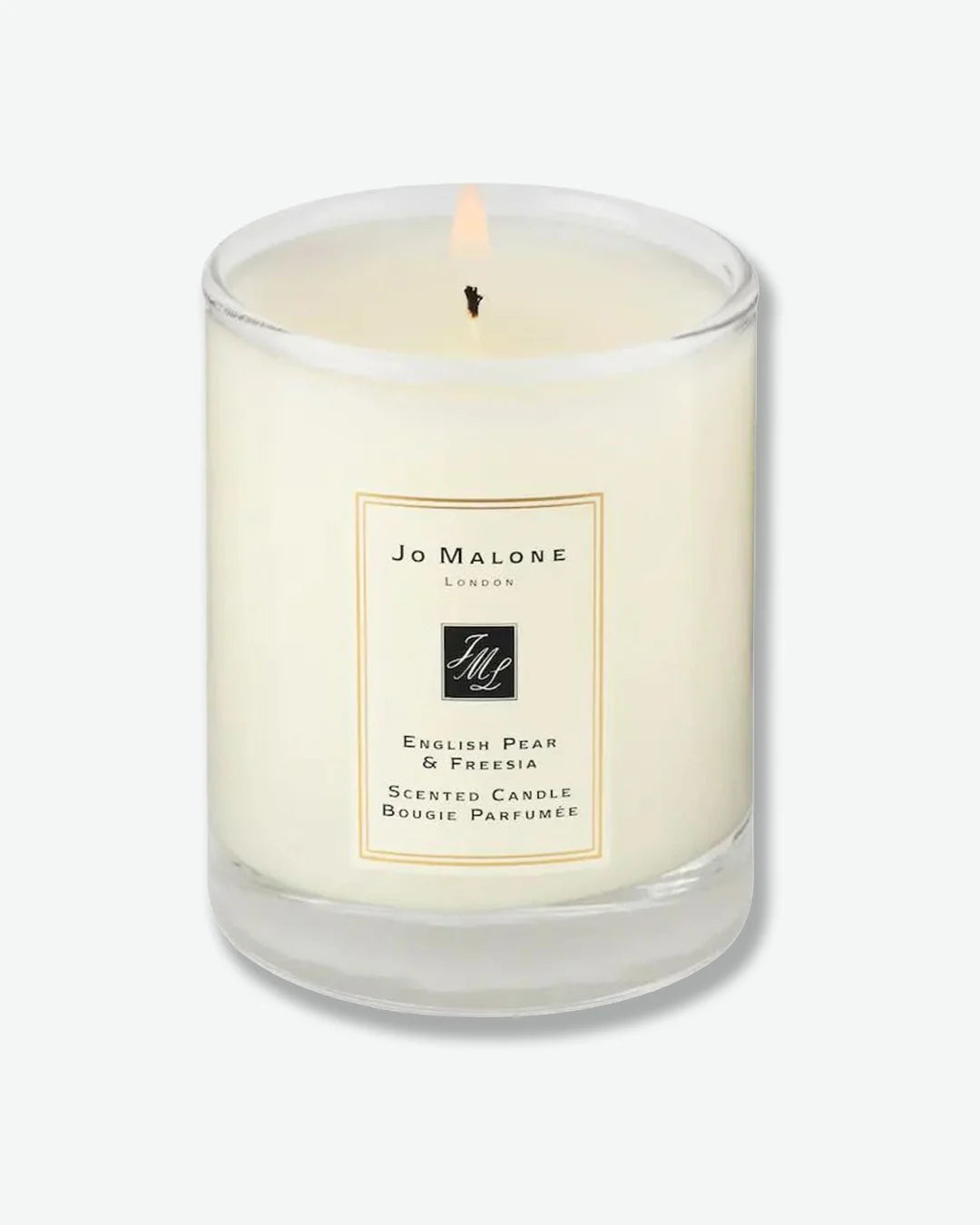 A lit Jo Malone English Pear & Freesia scented candle in a glass jar 