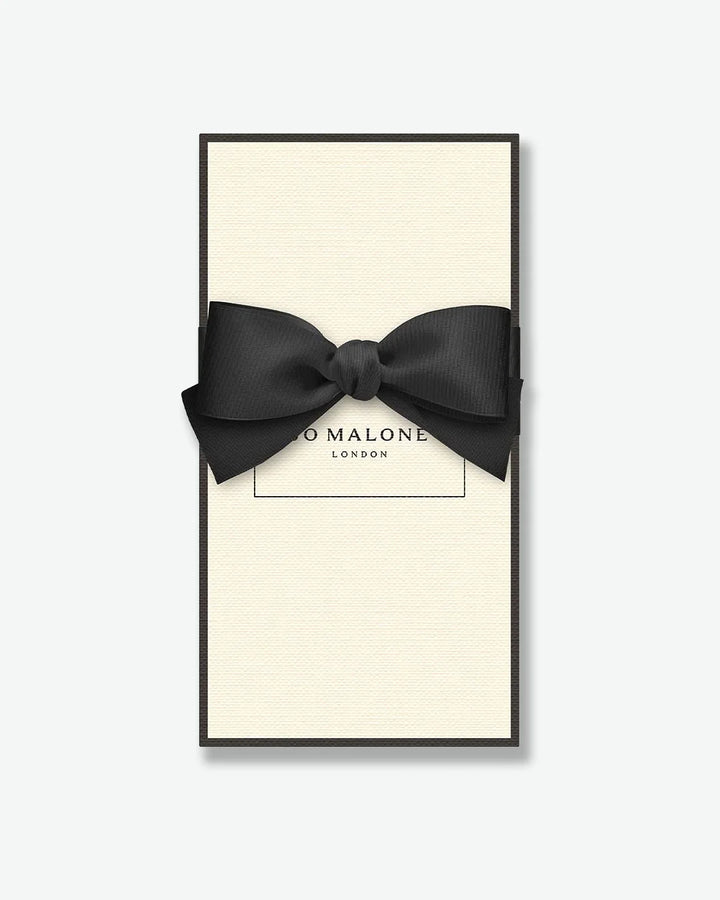 Black bow tie in a 'Jo Malone London' box on a white background