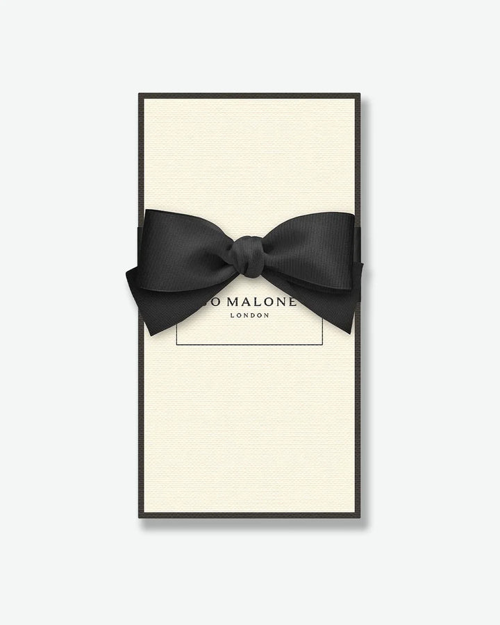 Black bow tie in a 'Jo Malone London' box on a white background