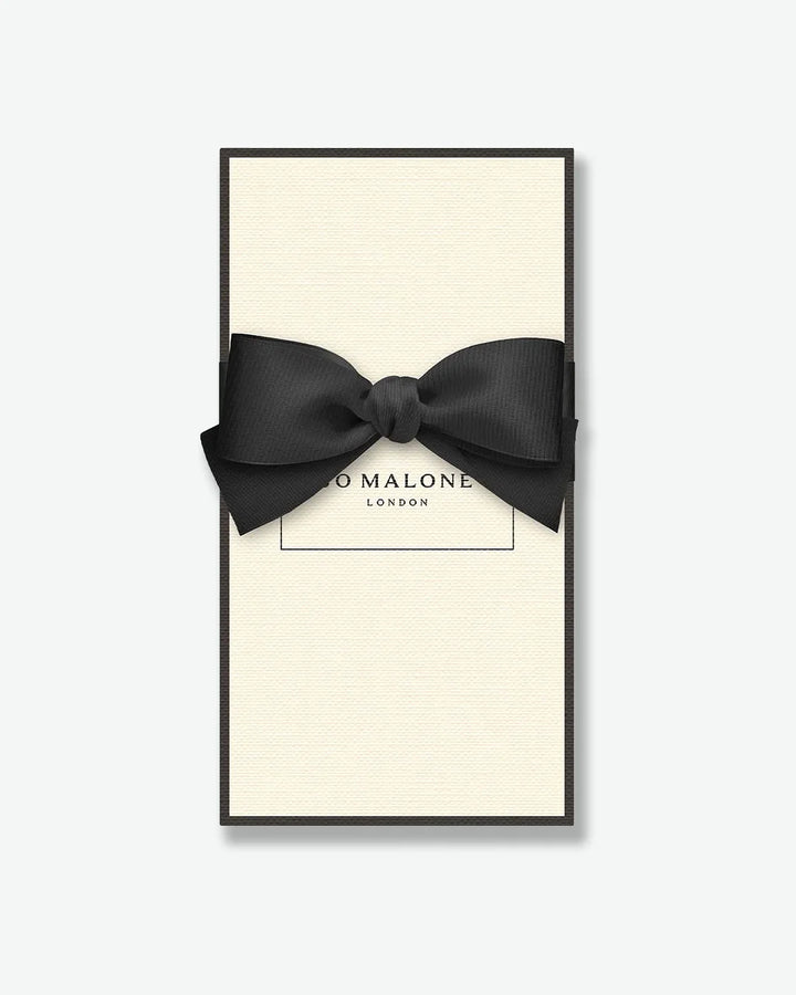 Black bow tie in a 'Jo Malone London' box on a white background