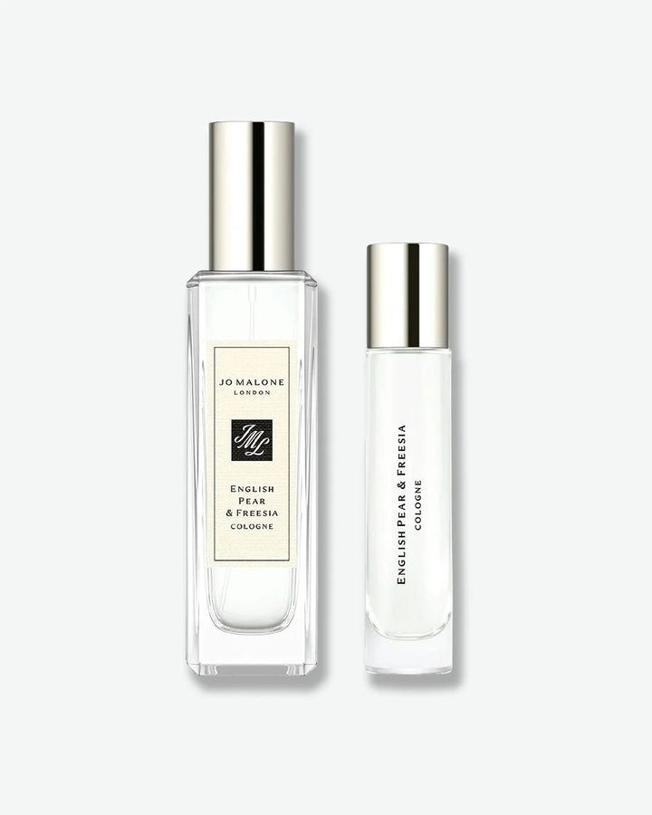 Jo Malone London English Pear & Freesia Cologne set, featuring a standard rectangular spray bottle next to a smaller, slender cylindrical travel-sized bottle, both topped with silver caps.