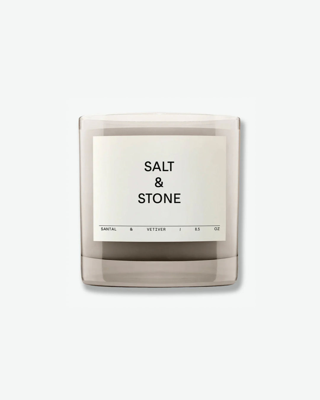 Salt & Stone Santal & Vetiver 8.5 oz scented candle in a minimalist translucent grey glass jar with a square off-white label, isolated against a light grey background.
