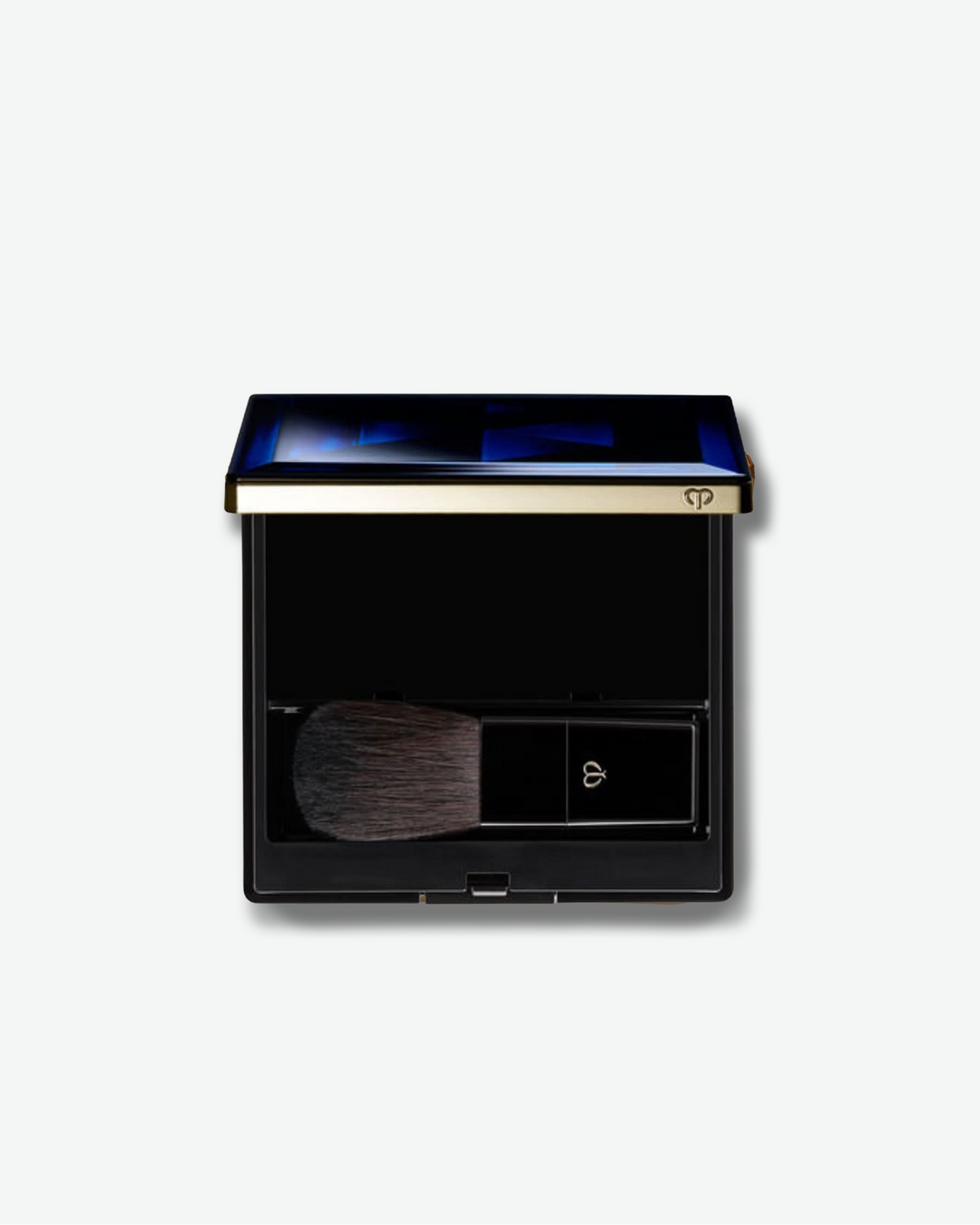Makeup compact with brush on a light gray background