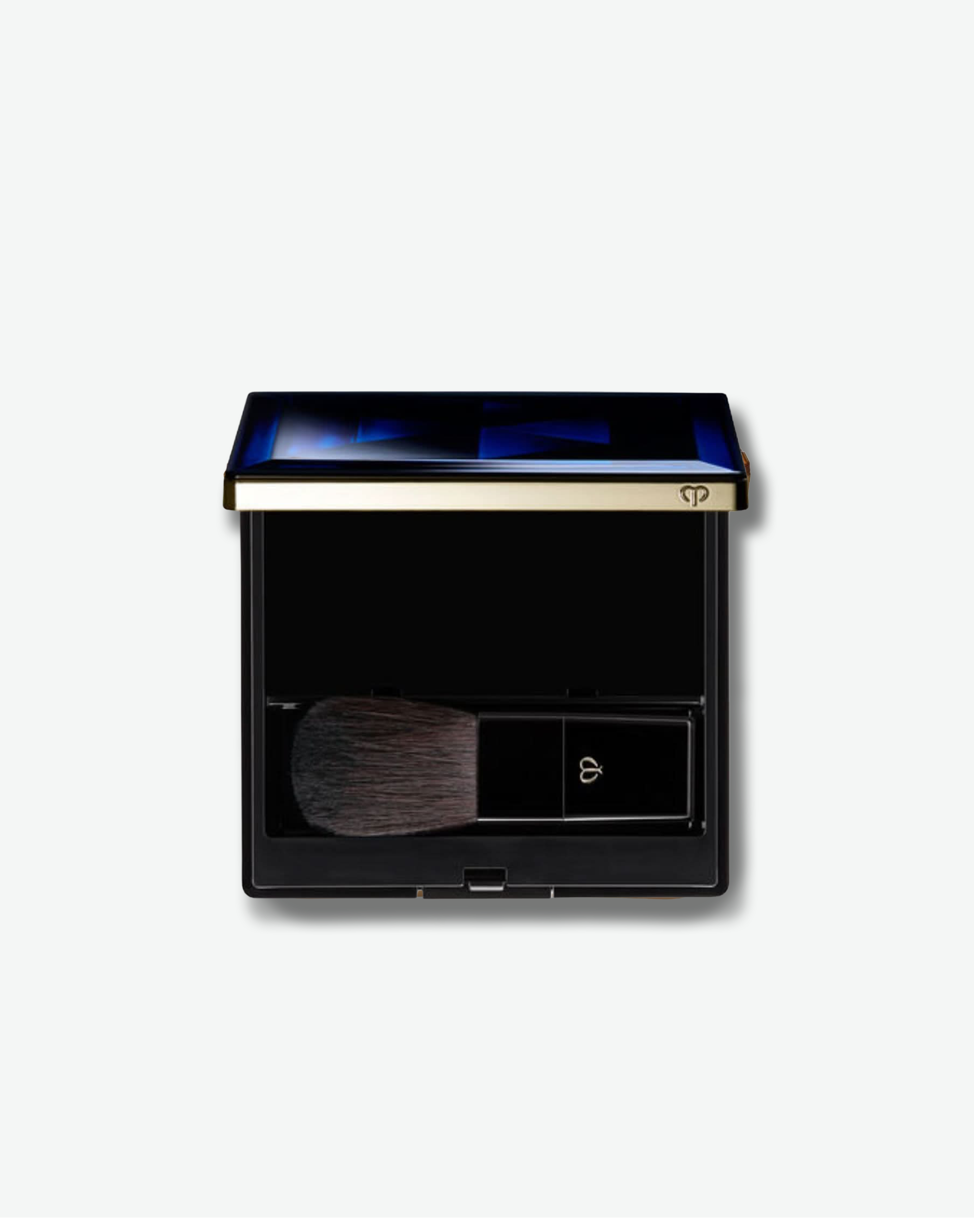 Makeup compact with brush on a light gray background