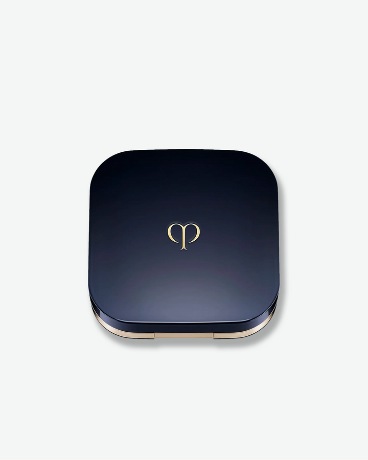 Blue compact powder case with a gold logo on a white background
