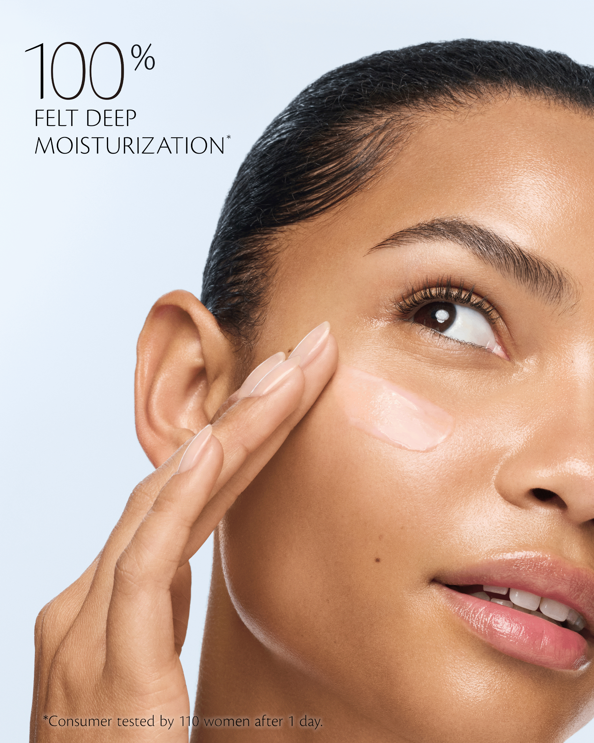 Close-up of a woman applying or spreading a light cream product on her cheek, with text reading '100% FELT DEEP MOISTURIZATION' on a pale blue background.