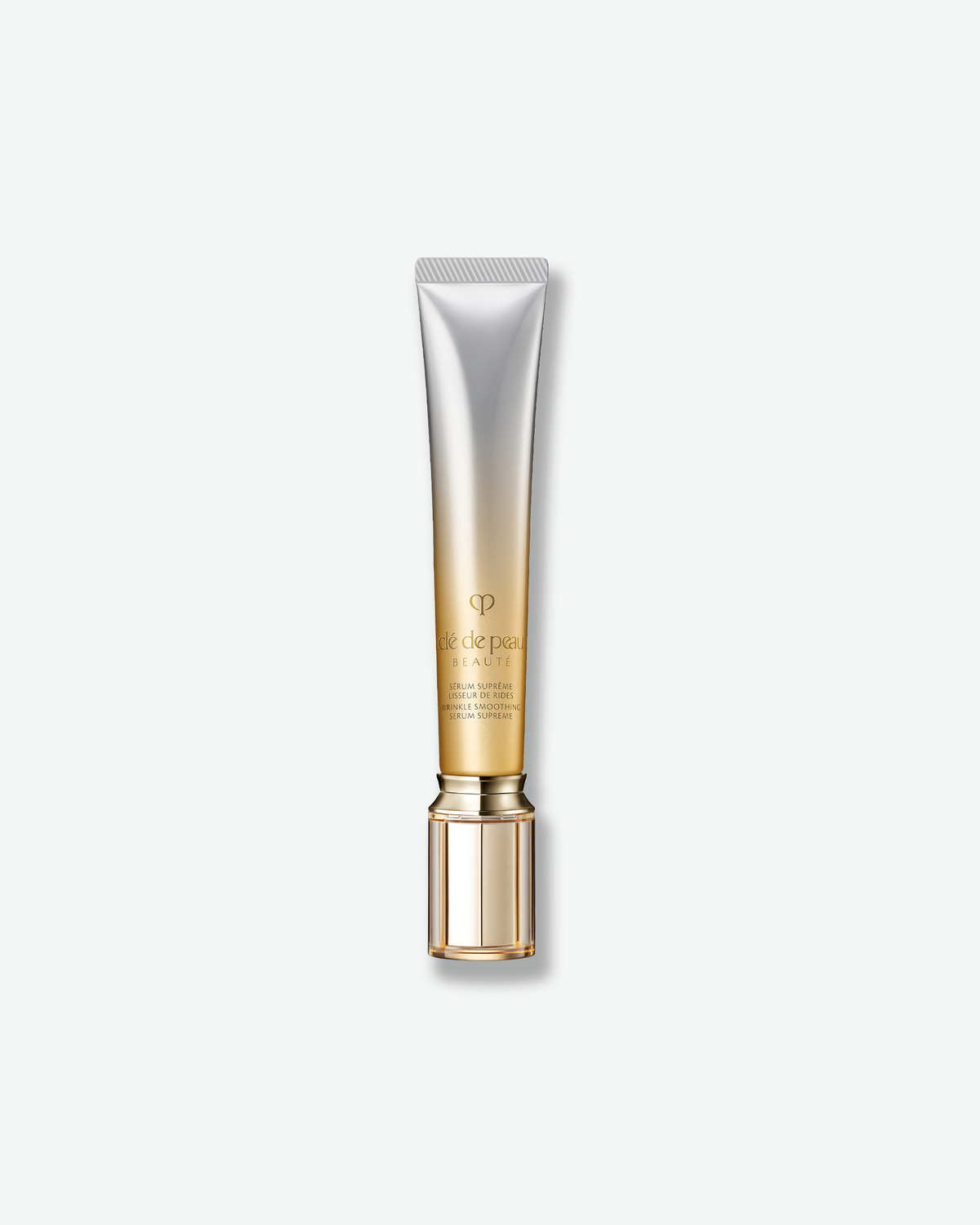 Clé de Peau Beauté Supreme Wrinkle Smoothing Serum in a silver and gold tube on a light background.