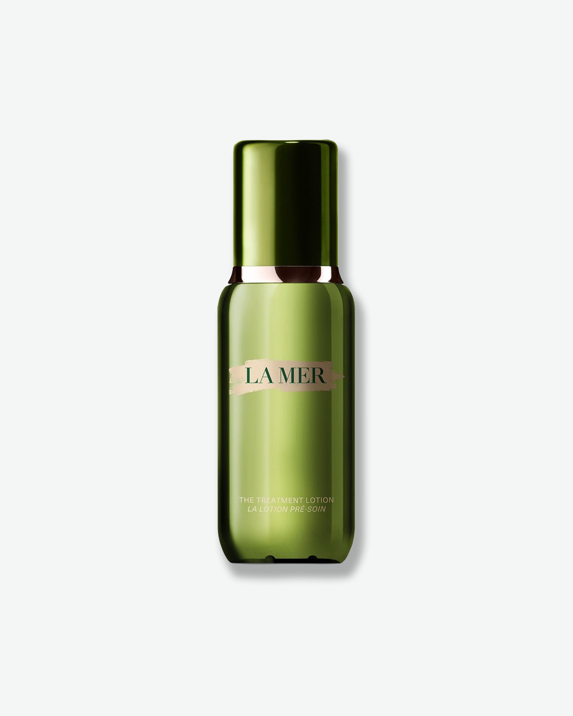 La Mer The Treatment Lotion in a translucent olive green bottle with a matching cap, featuring a gold and pinkish-beige brand label, set against a light gray background.