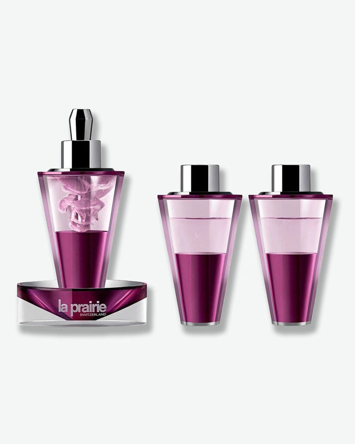 Three La Prairie skincare bottles with a gradient design on a white background