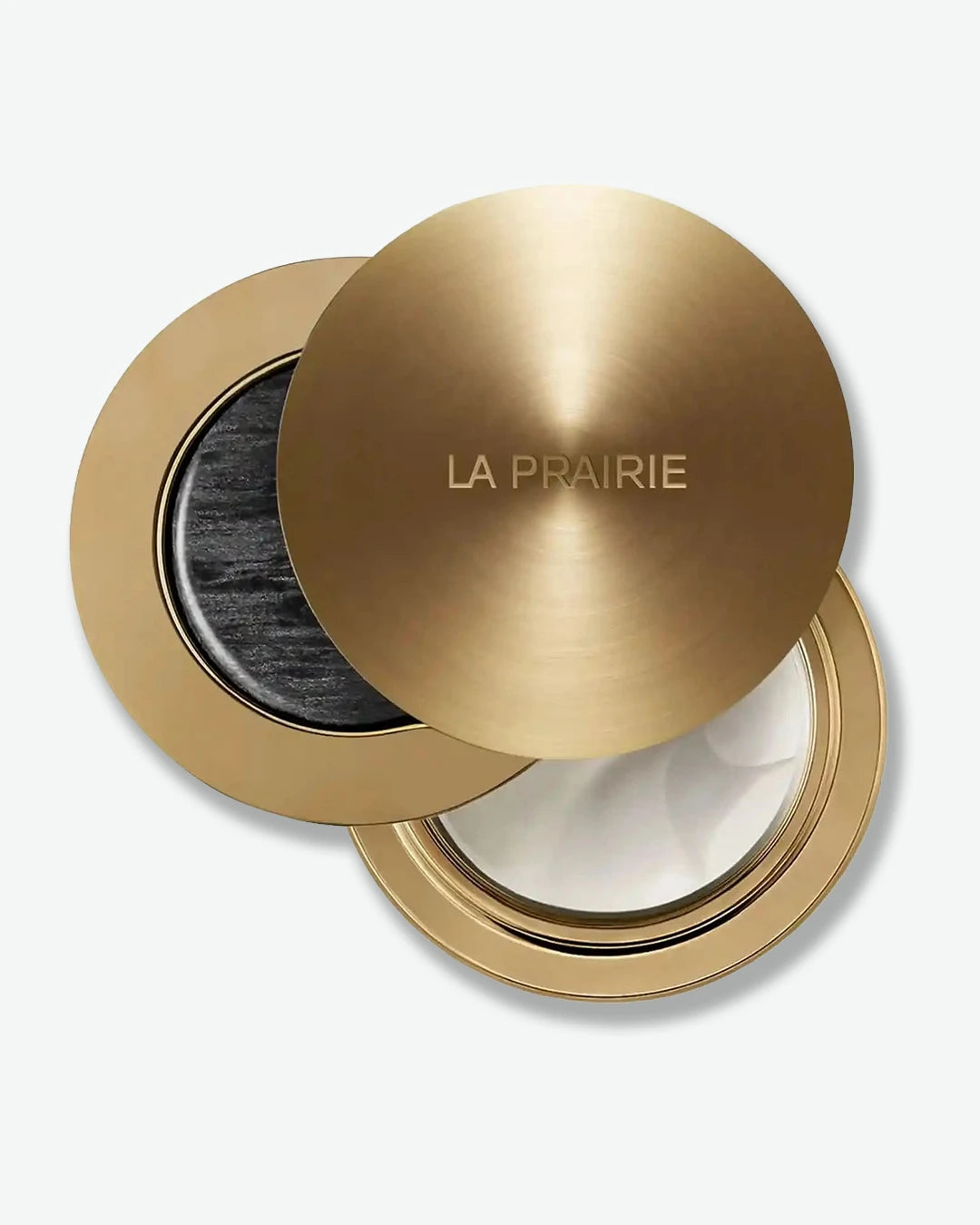 Gold cosmetic case with 'La Prairie' branding and balm on a white background