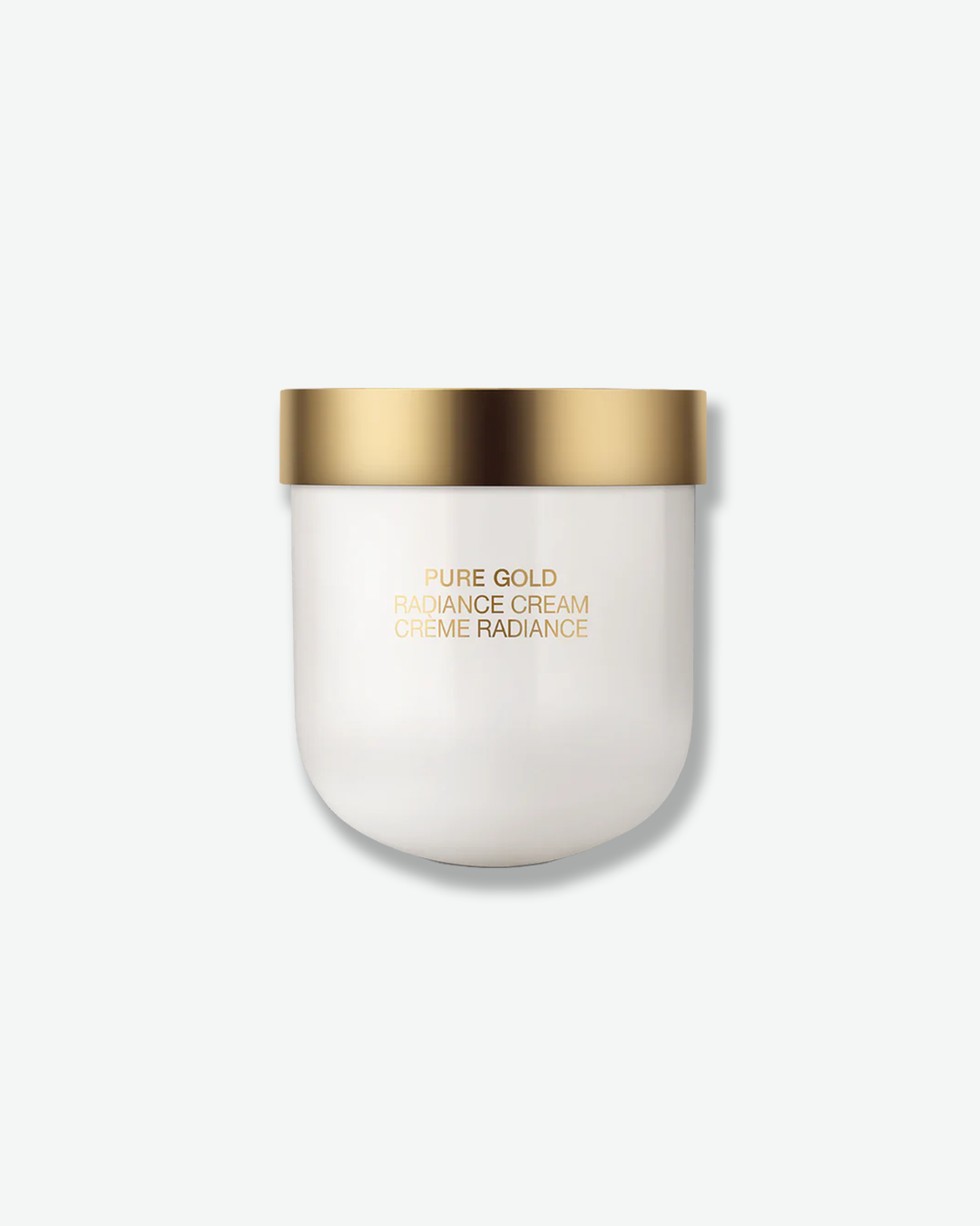 Front view of a La Prairie Pure Gold Radiance Cream container against a plain gray background. The minimalist vessel features a smooth, opaque white u-shaped ceramic body with gold-foil lettering, capped with a flat, matte gold metallic lid.