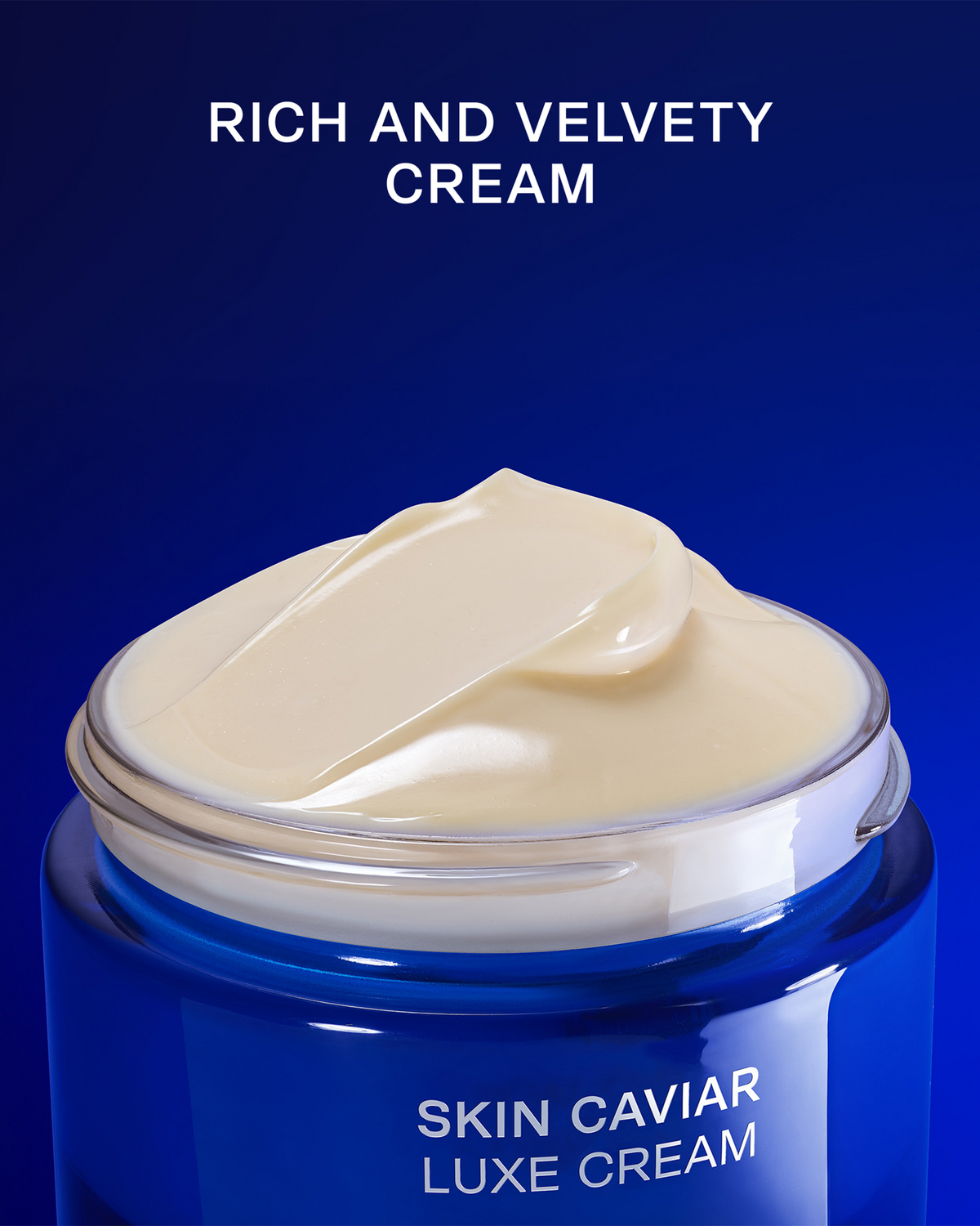 An open blue cosmetic jar filled with thick, creamy off-white cream, set against a deep blue background with white text reading 'RICH AND VELVETY CREAM' and 'SKIN CAVIAR LUXE CREAM'.