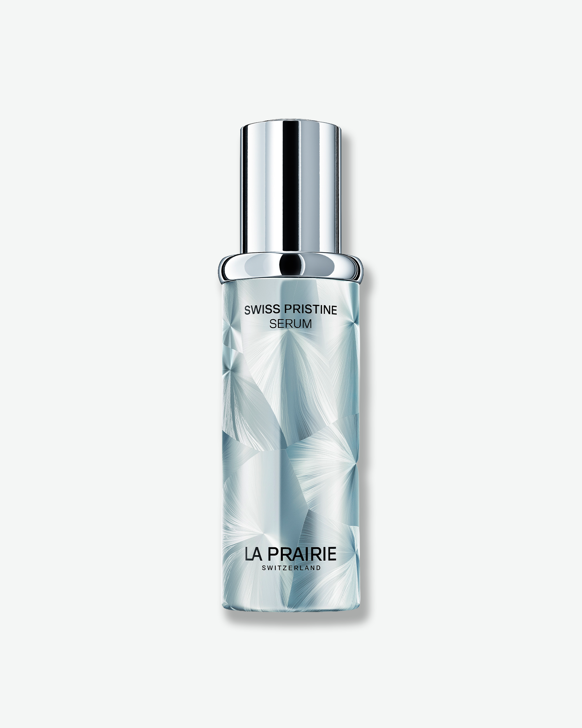 La Prairie Swiss Pristine Serum in an icy blue, faceted bottle with a reflective silver cap on a clean white background.