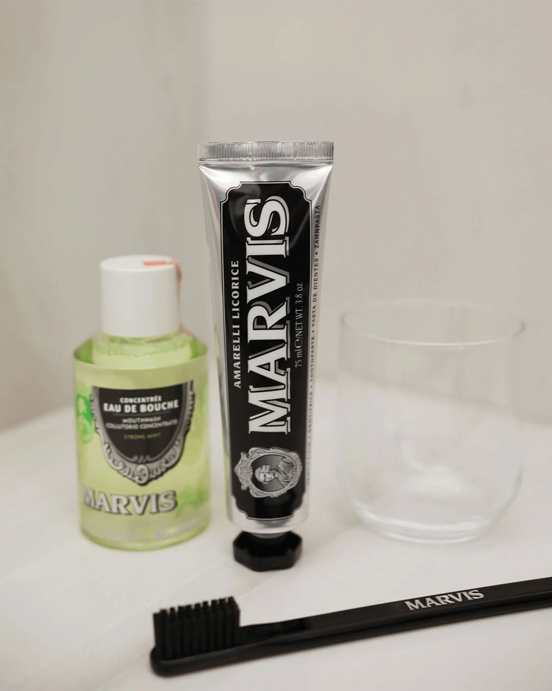 Marvis mouthwash, toothpaste, and toothbrush on a white surface