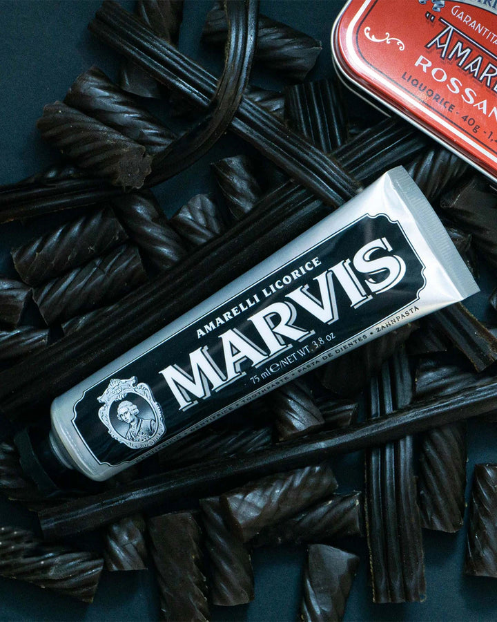 Marvis licorice packaging with licorice sticks on a dark background