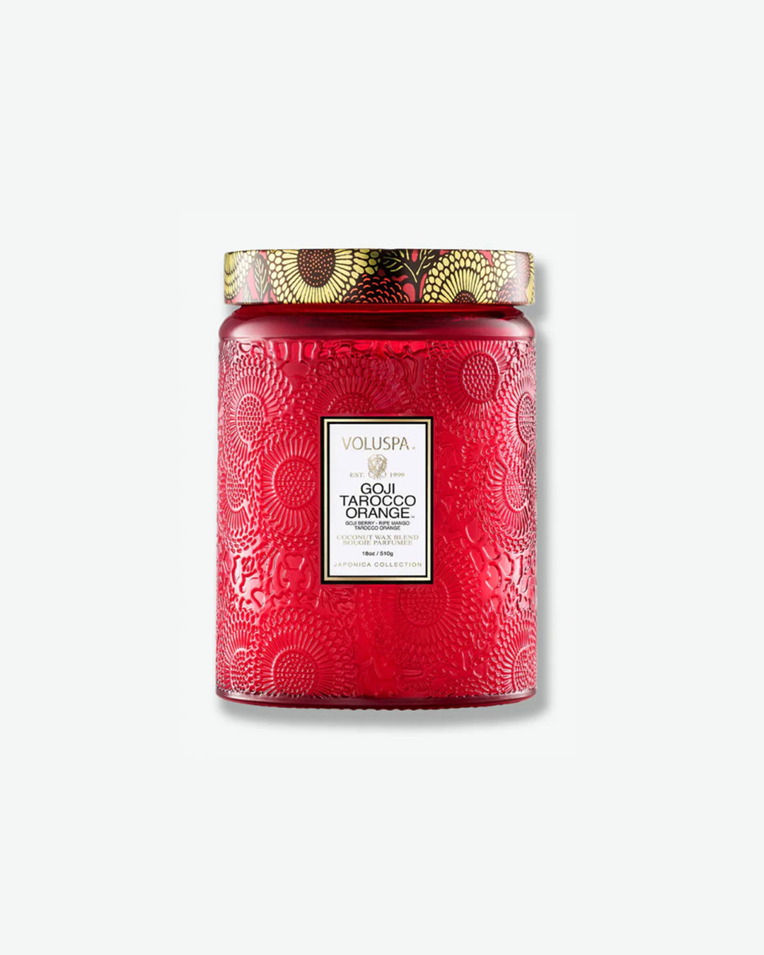 Front view of a Voluspa Goji Tarocco Orange large jar candle against a plain gray background. The candle features a deep red glass jar embossed with a detailed floral motif, a white central label with gold framing, and a decorative tin lid adorned with a black, red, and yellow floral pattern.