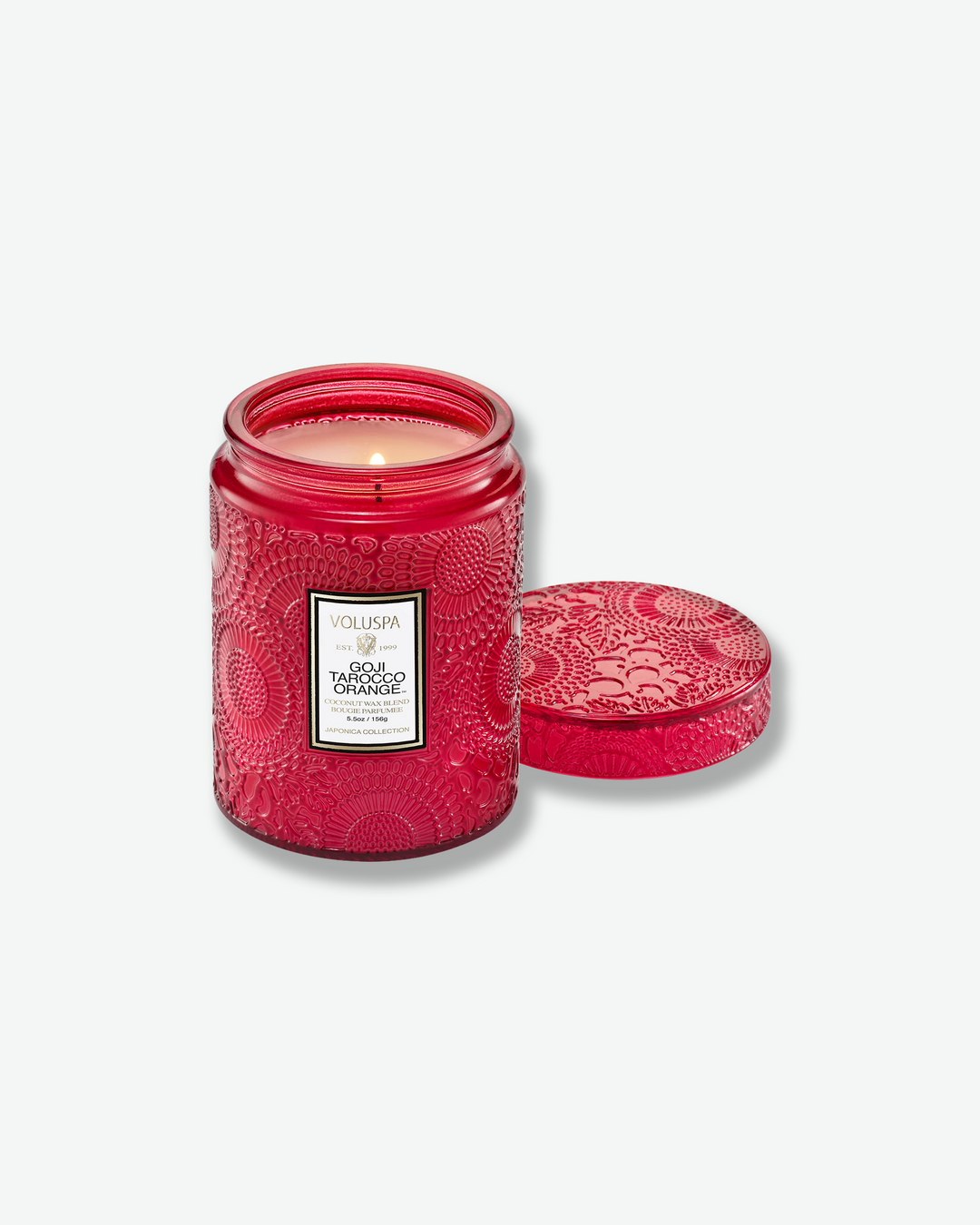 Front view of a Voluspa Goji Tarocco Orange small jar candle against a plain gray background. The candle features a deep red glass body completely embossed with swirling floral designs and a central white product label, topped with a matching textured glass lid.