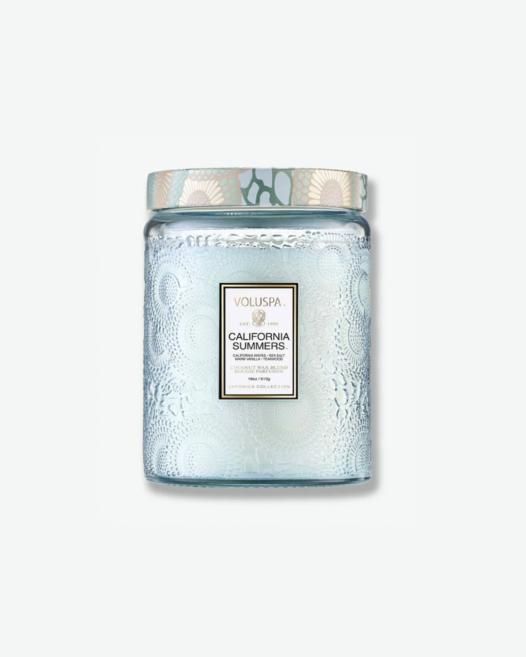 Front view of a Voluspa California Summers large jar candle against a plain gray background. The translucent, light icy-blue glass jar features a detailed embossed floral design, a central product label, and a patterned tin lid styled with a matching blue and cream botanical motif.