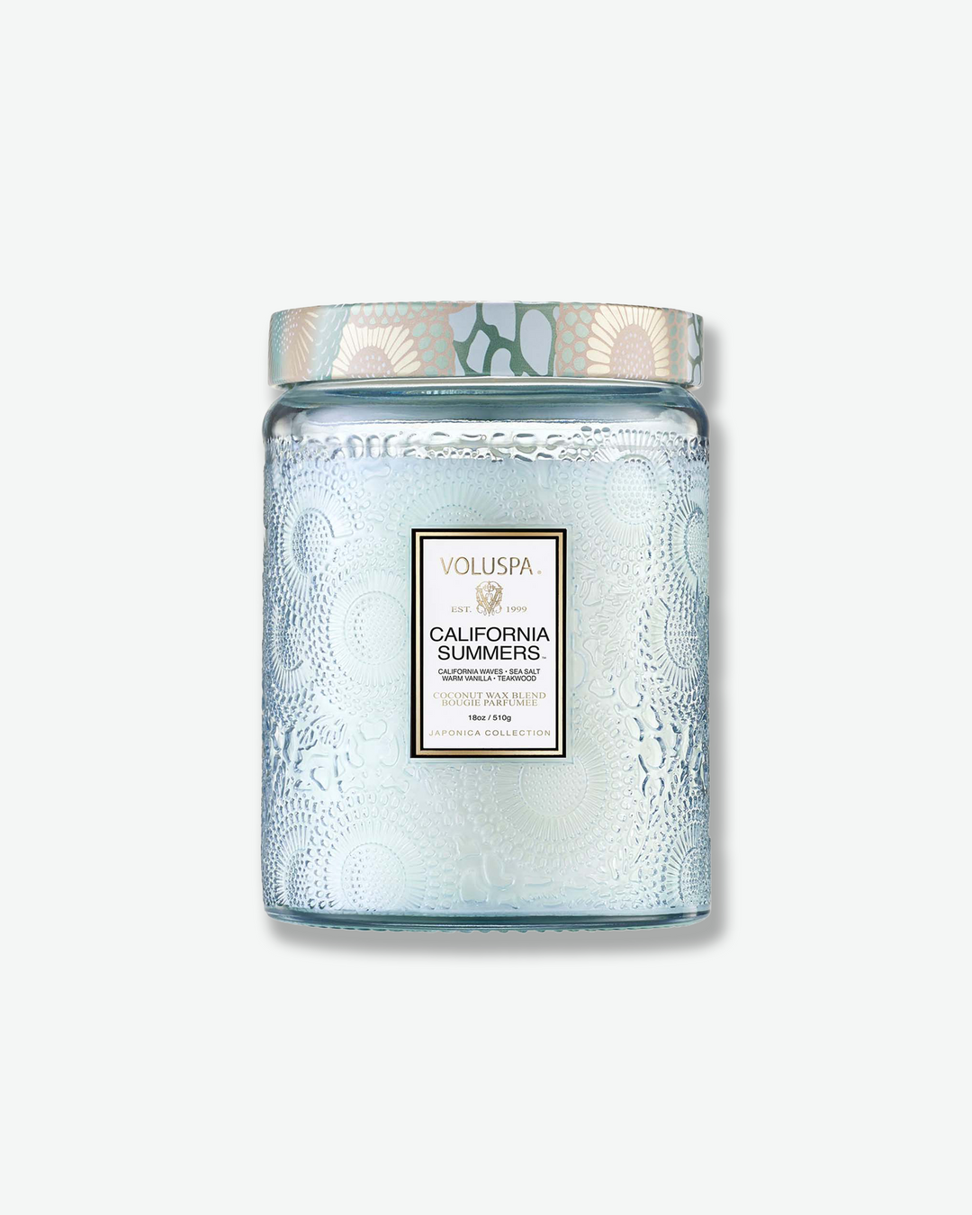 Front view of a Voluspa California Summers large jar candle against a plain gray background. The translucent, light icy-blue glass jar features a detailed embossed floral design, a central product label, and a patterned tin lid styled with a matching blue and cream botanical motif.