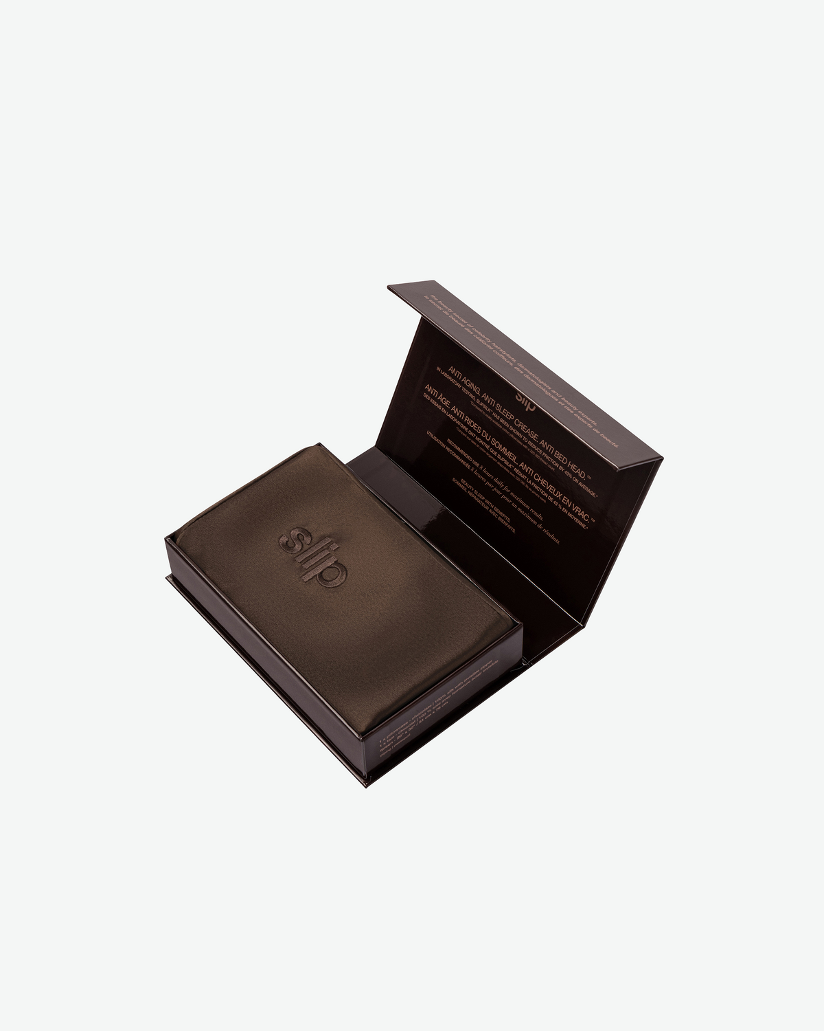 Slip Pure Silk Pillowcase in chocolate brown, neatly folded inside an open luxury gift box with embossed Slip branding.
