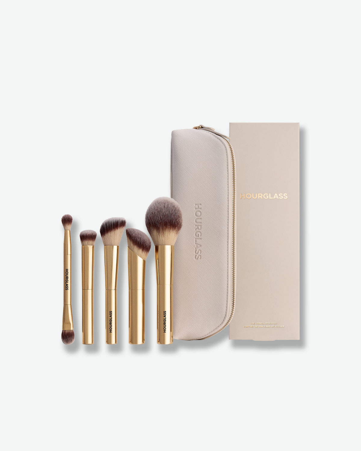 Hourglass Travel Brush Set featuring five gold makeup brushes, a cream zippered travel case, and coordinating packaging.