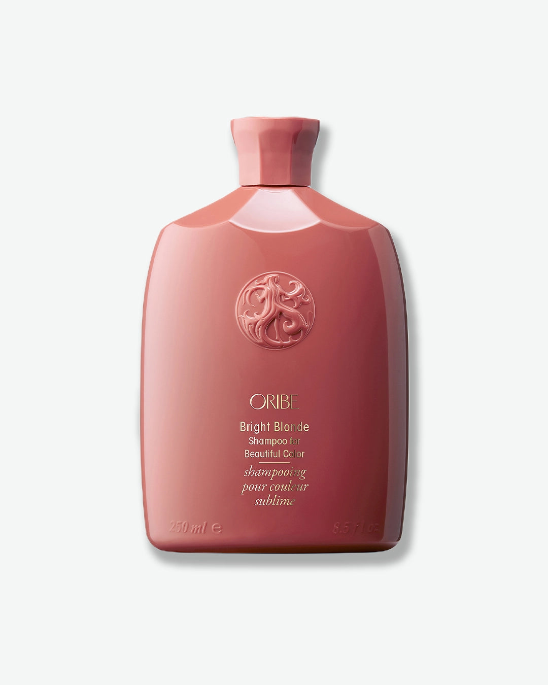 Pink shampoo bottle with Oribe logo on a white background