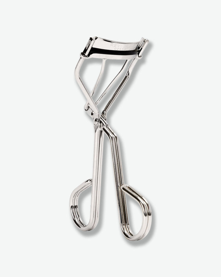 Metallic eyelash curler on a white background