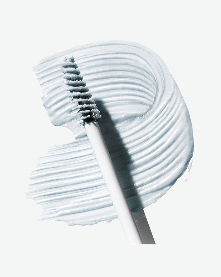 White eyebrow brush with white brow masque on a white background