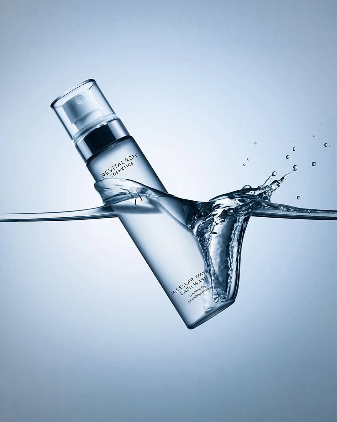 Revitalash bottle with water splash on a light blue background