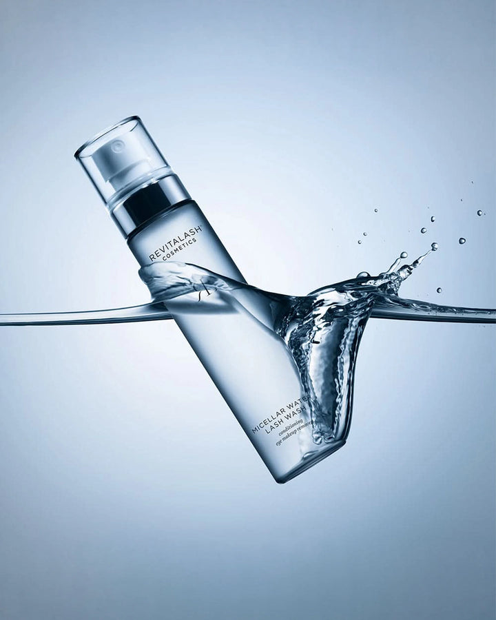 Revitalash bottle with water splash on a light blue background