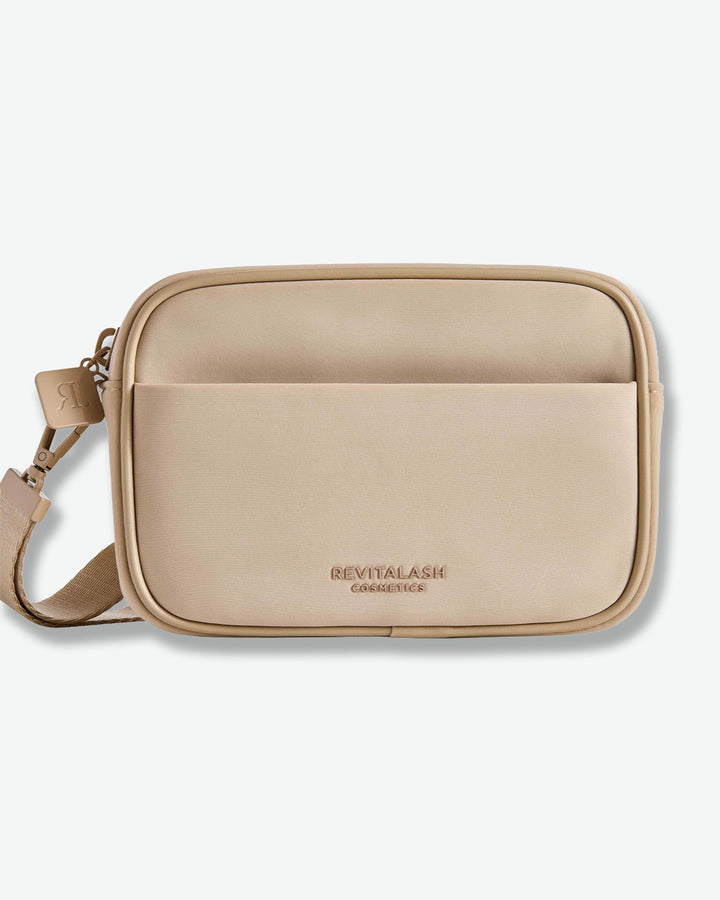 Beige crossbody bag with 'Revitalash' branding on a white background