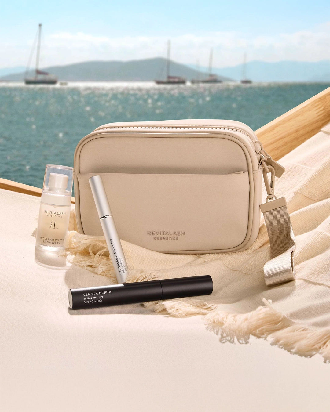Beige cosmetic bag with makeup products on a sandy beach with ocean view