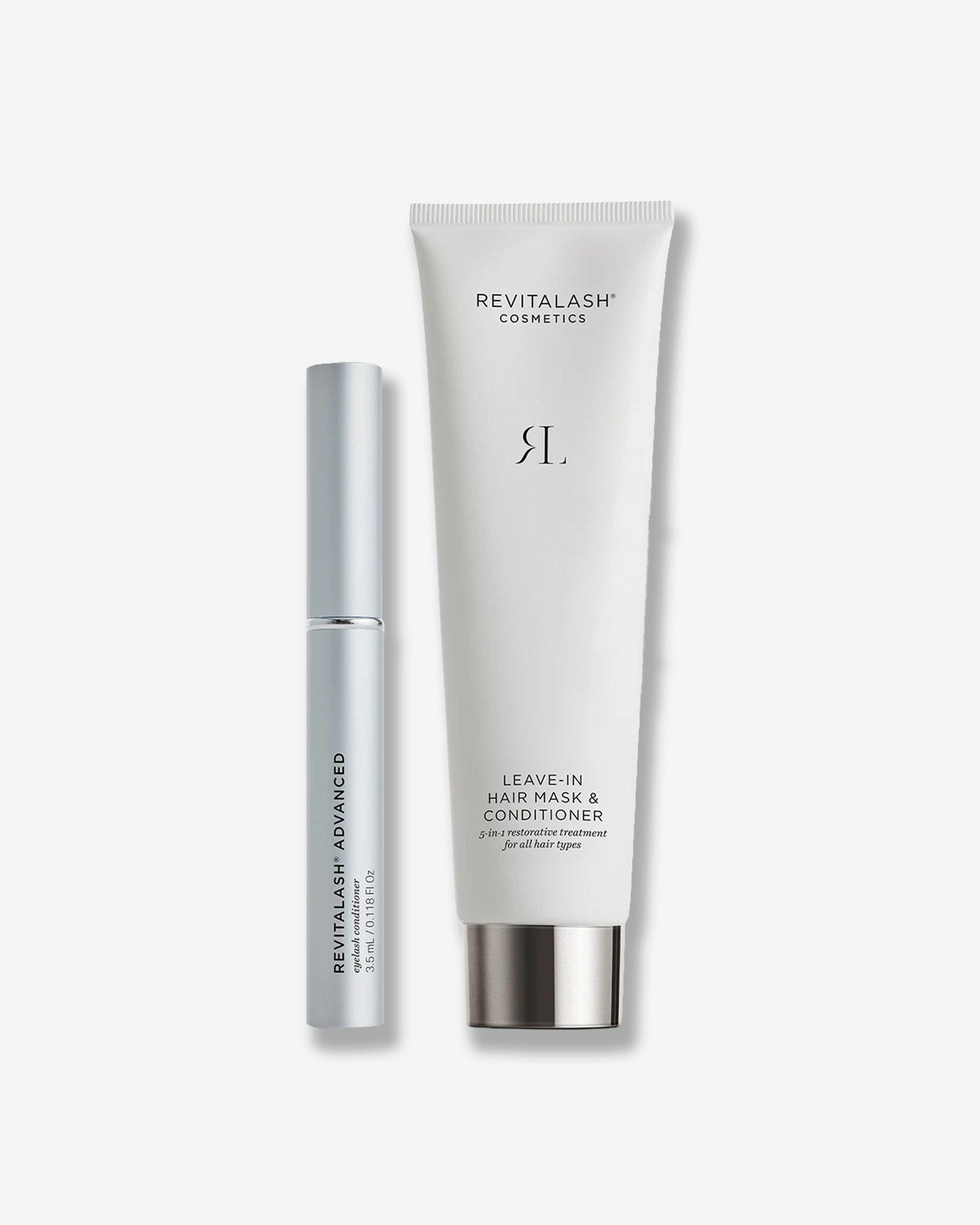 Product duo featuring RevitaLash Cosmetics items standing vertically side-by-side. On the left is a slender, matte silver tube of RevitaLash Advanced Eyelash Conditioner. On the right is a white squeeze tube of Leave-In Hair Mask & Conditioner with a polished silver cap.