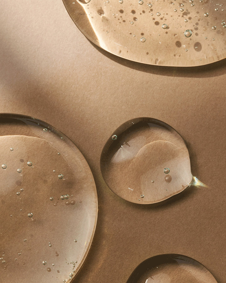 Close-up of bronze-colored metal surfaces with water droplets.