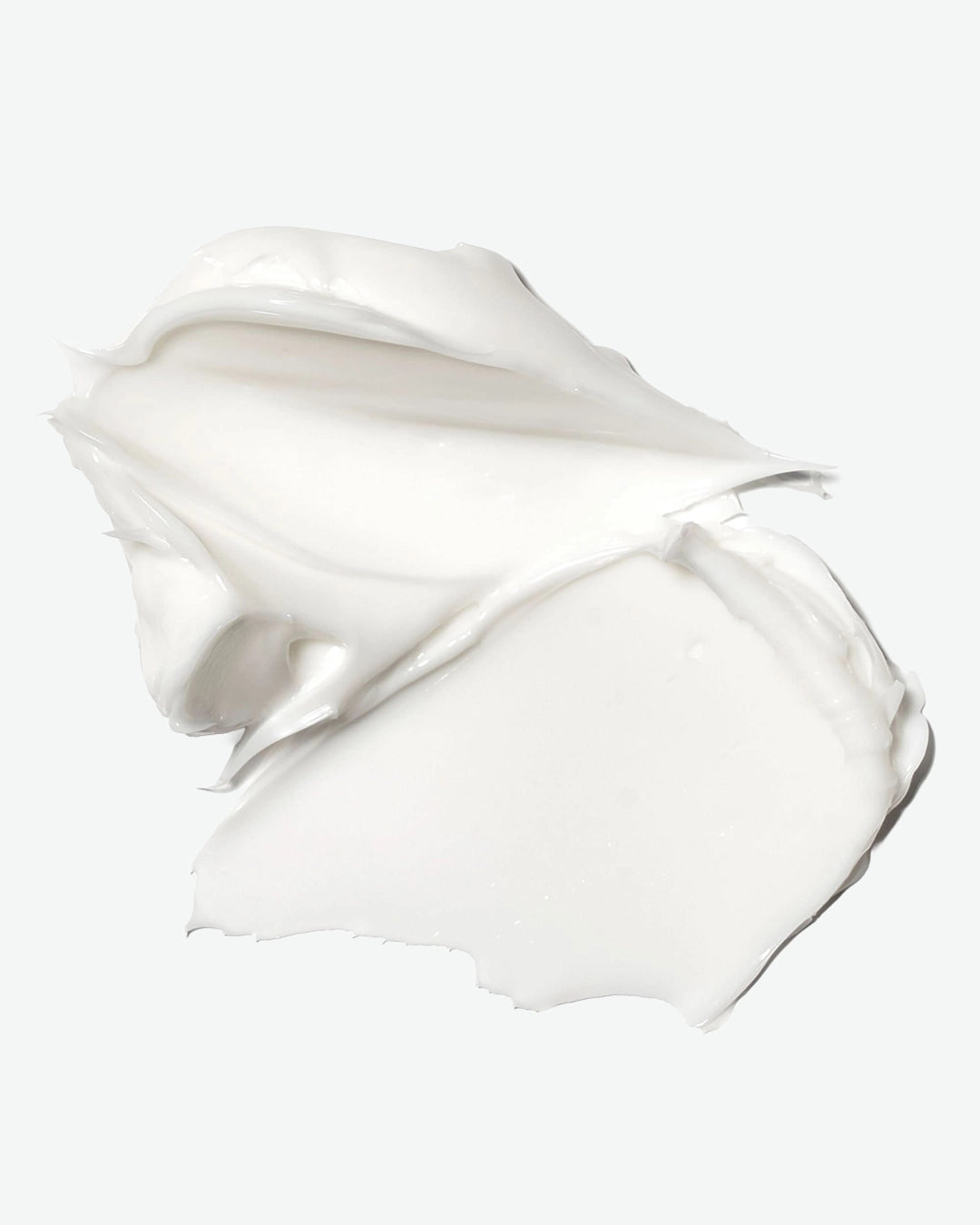 White cream or lotion in a swirled shape on a light gray background