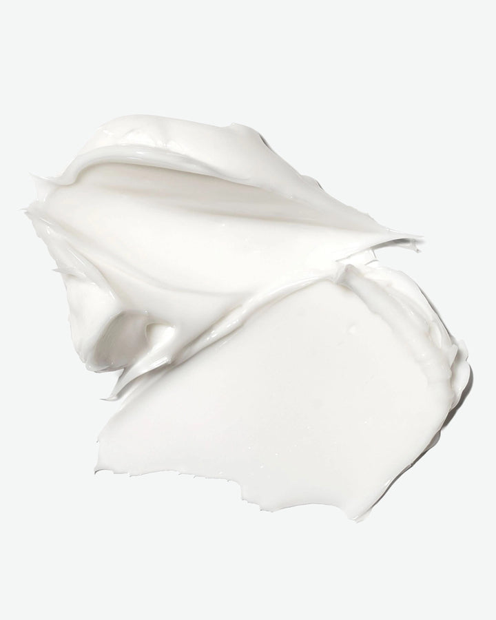 White cream or lotion in a swirled shape on a light gray background