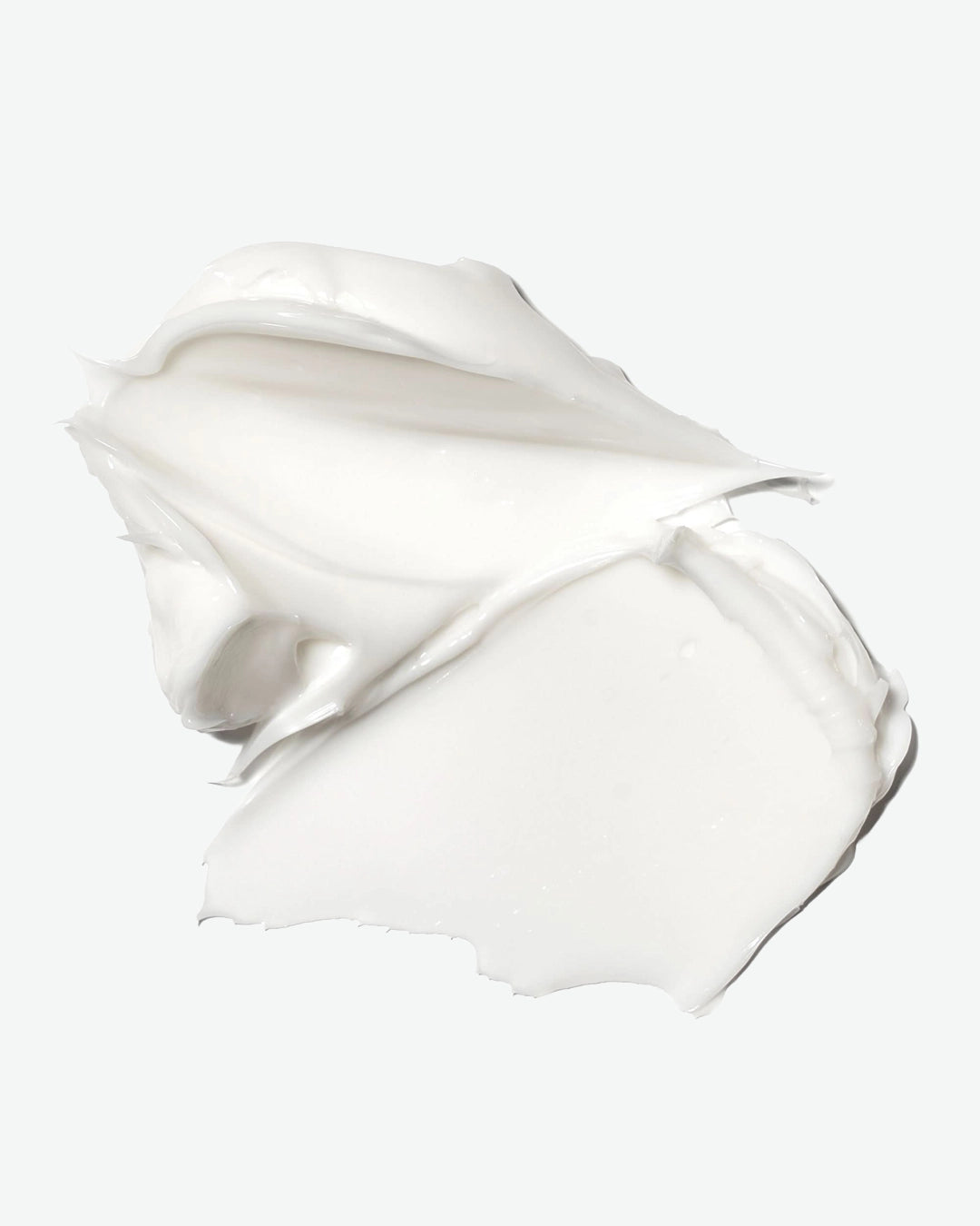 White cream or lotion in a smooth, flowing shape on a white background
