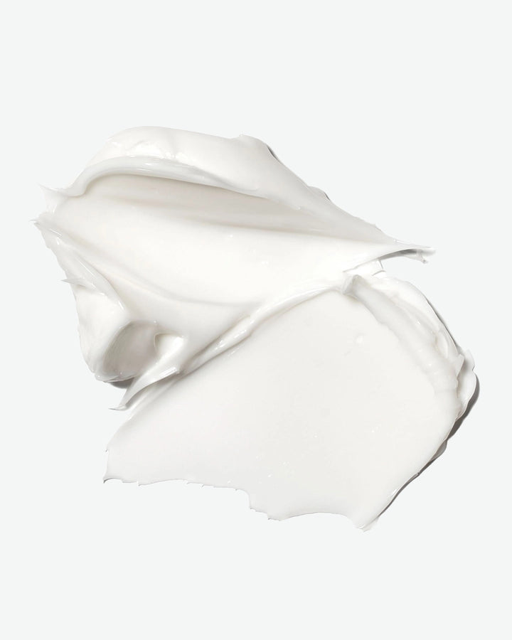 White cream or lotion in a smooth, flowing shape on a white background