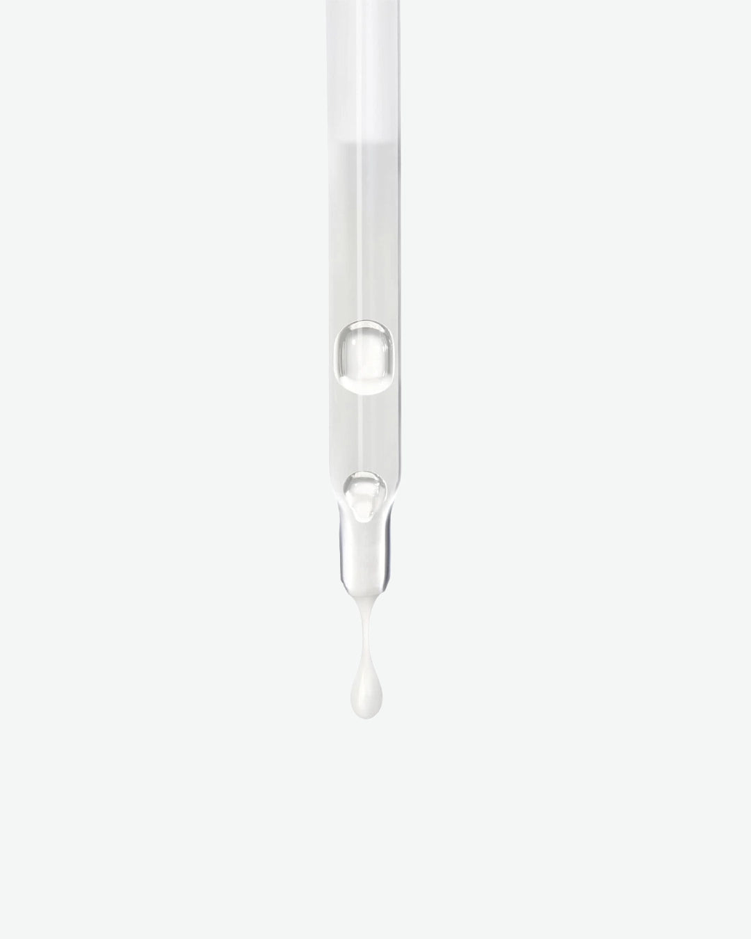 Transparent dropper with a drop of liquid on a white background