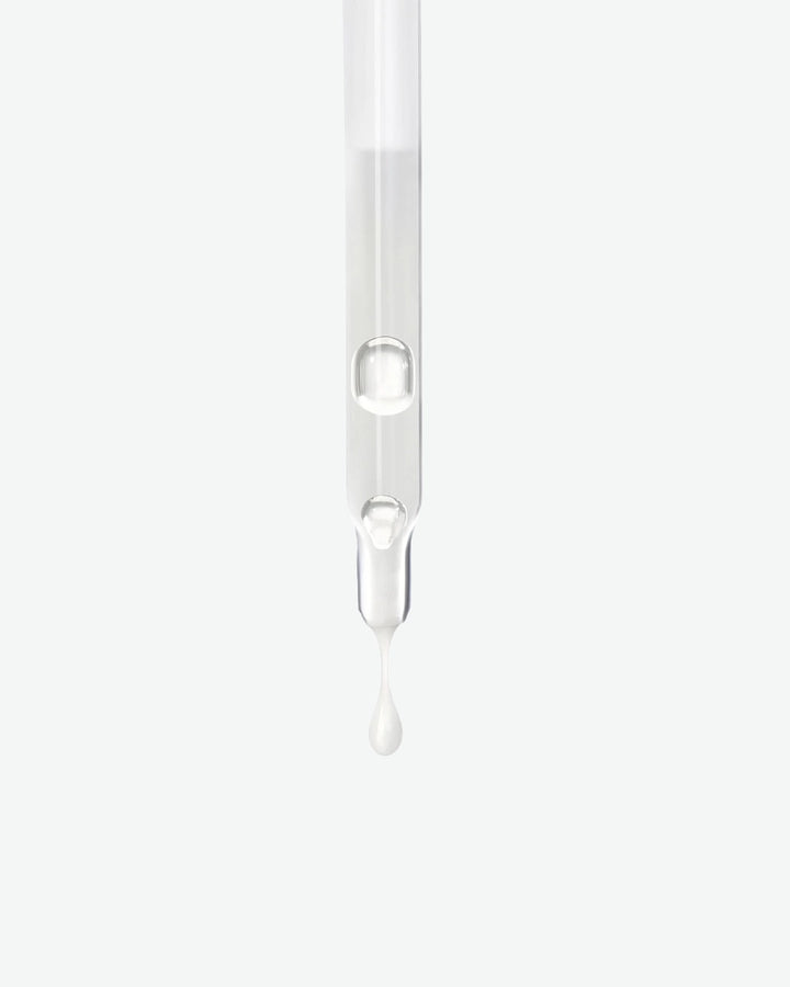 Transparent dropper with a drop of liquid on a white background