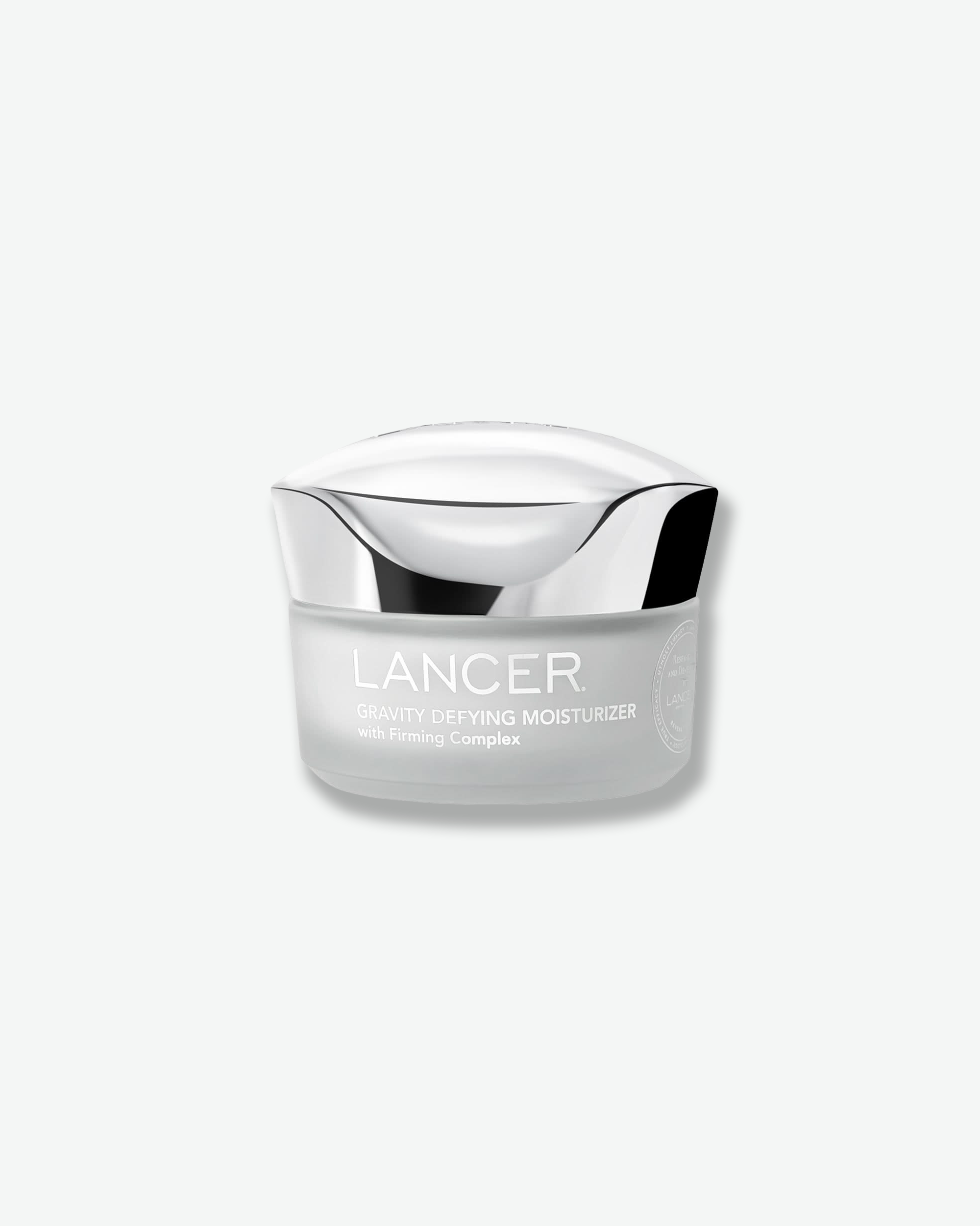 Front view of a Lancer Gravity Defying Moisturizer jar against a plain gray background. The cylindrical container features a frosted gray-white glass base printed with silver branding text, topped with a wavy, chrome metallic cap.